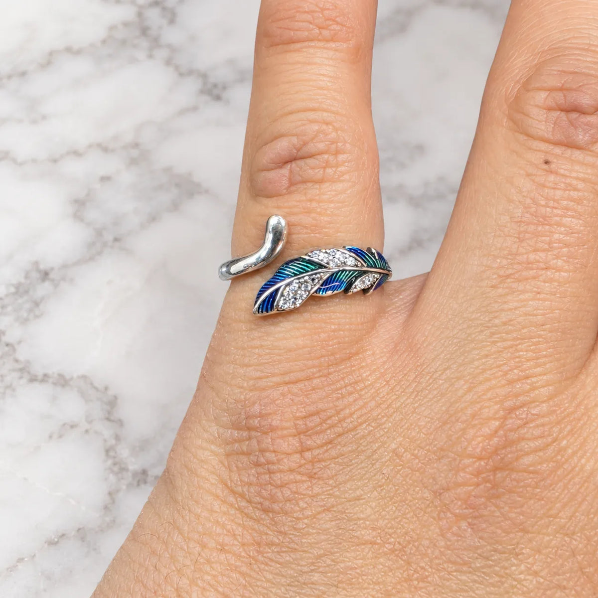 Anillo ajustable pluma azul microcircón