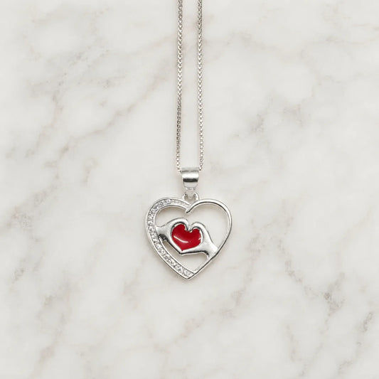 Collar corazón con manos y corazón rojo